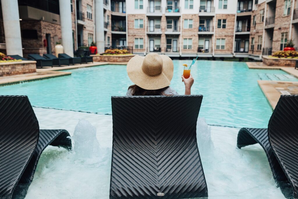 Woman holding a cocktail at the pool at Elan Med Center