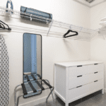 Closet with iron, ironing board, yoga mat, luggage rack and laundry bag
