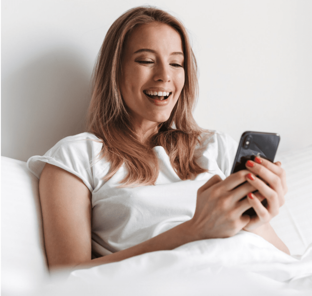woman in bed with her phone