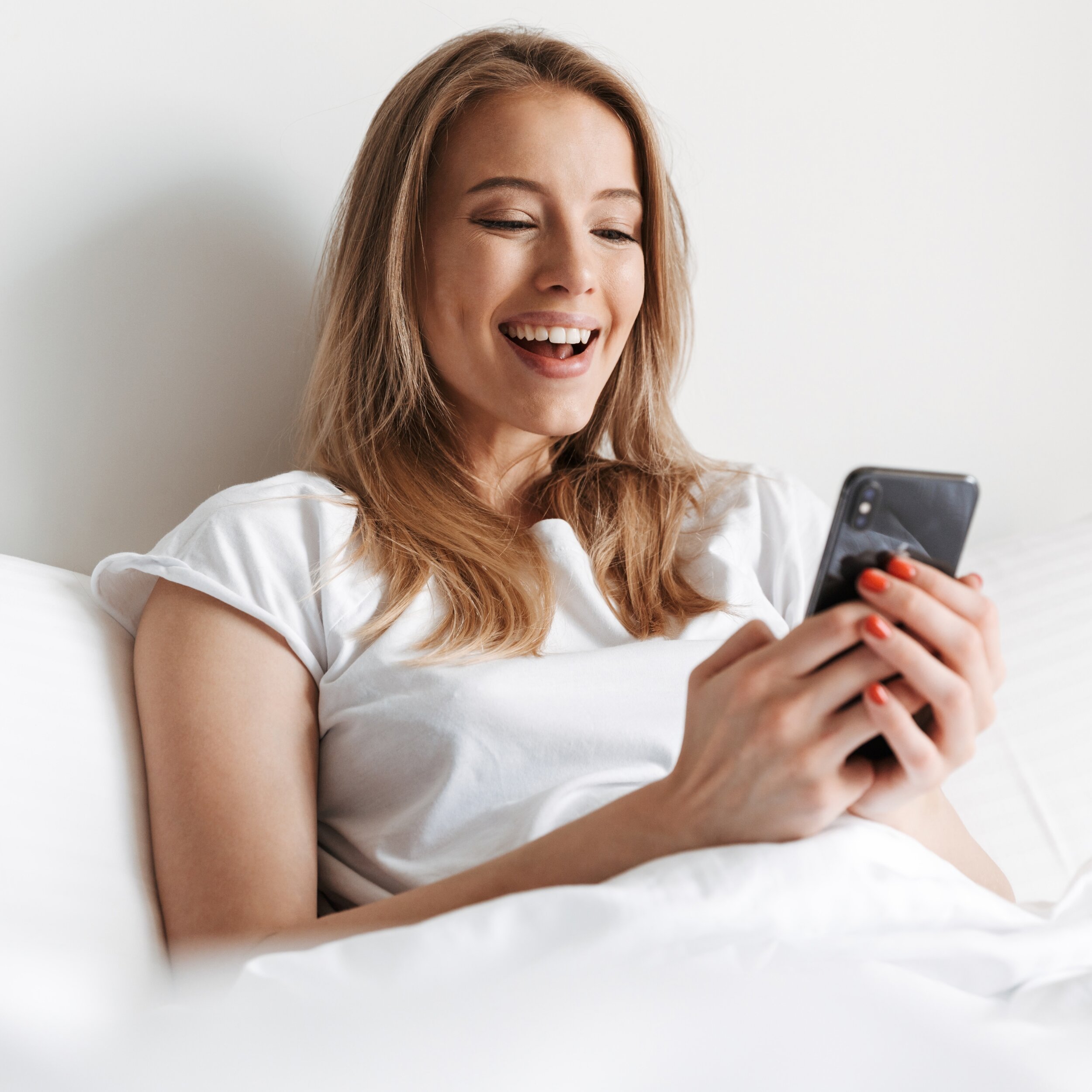 woman with phone in bed