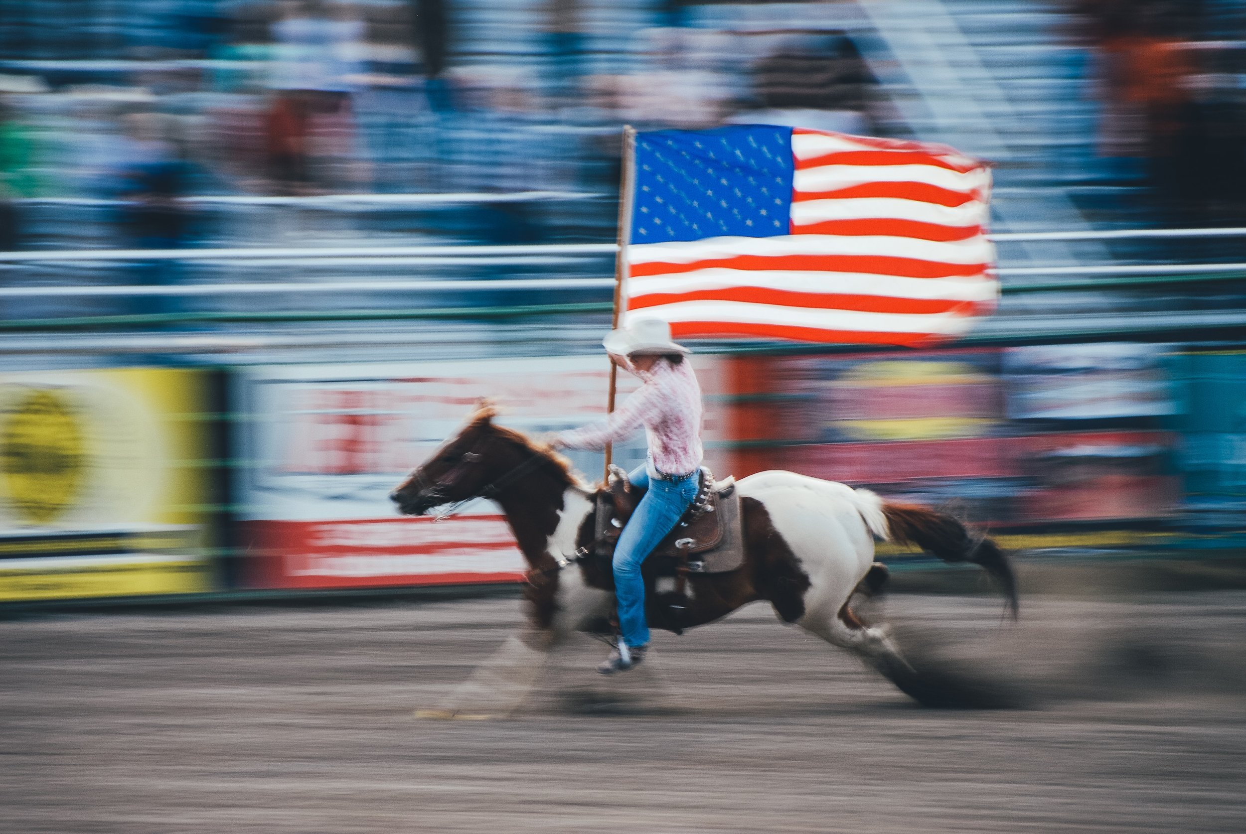 Woman riding a horse carrying a flag