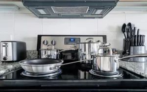Pots and pans on a stove with a toaster and knife block