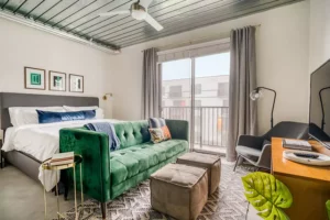 popular Lodgeur furnished studio apartment with green velvet couch and midcentury decor