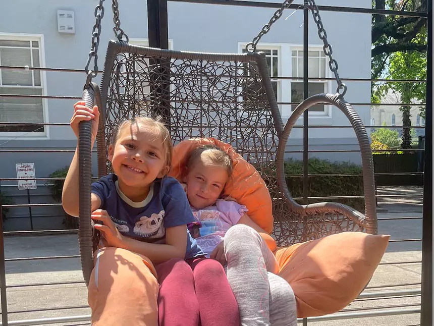 two children in a swing chair at Holman Draft Hall