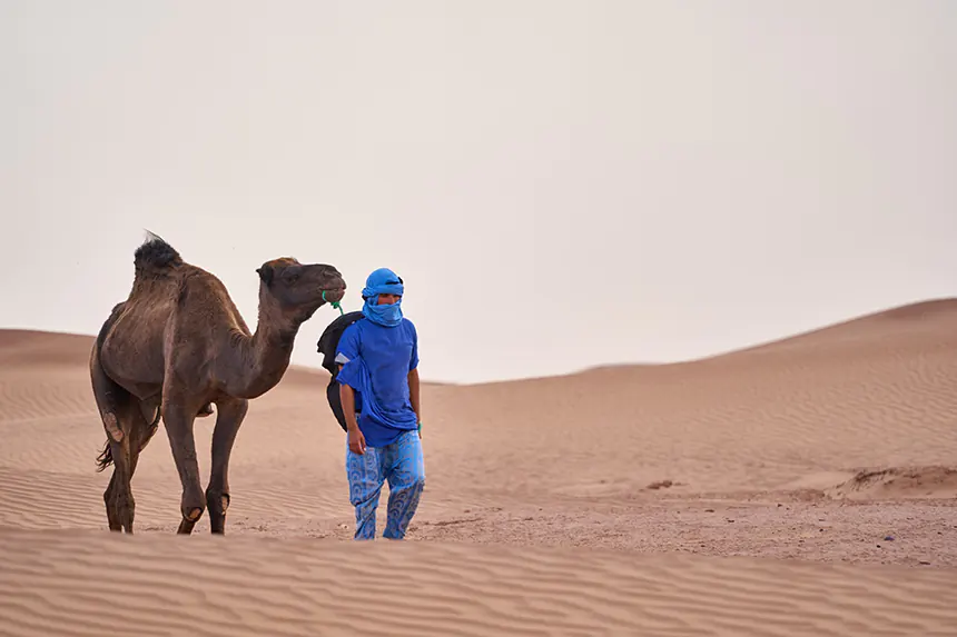 A more traditional nomad roaming the desert with a camel