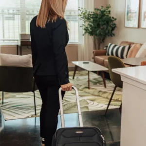 Image of a business person walking into Lodgeur corporate housing with their suitcase
