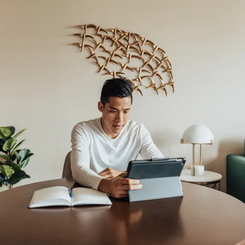 Image of an intern working on their computer at the dining table inside a Lodgeur furnished apartment