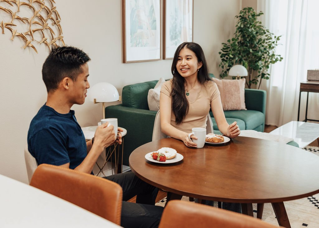Image of two people sitting at a dining table in an extended stay furnished apartment by Lodgeur.