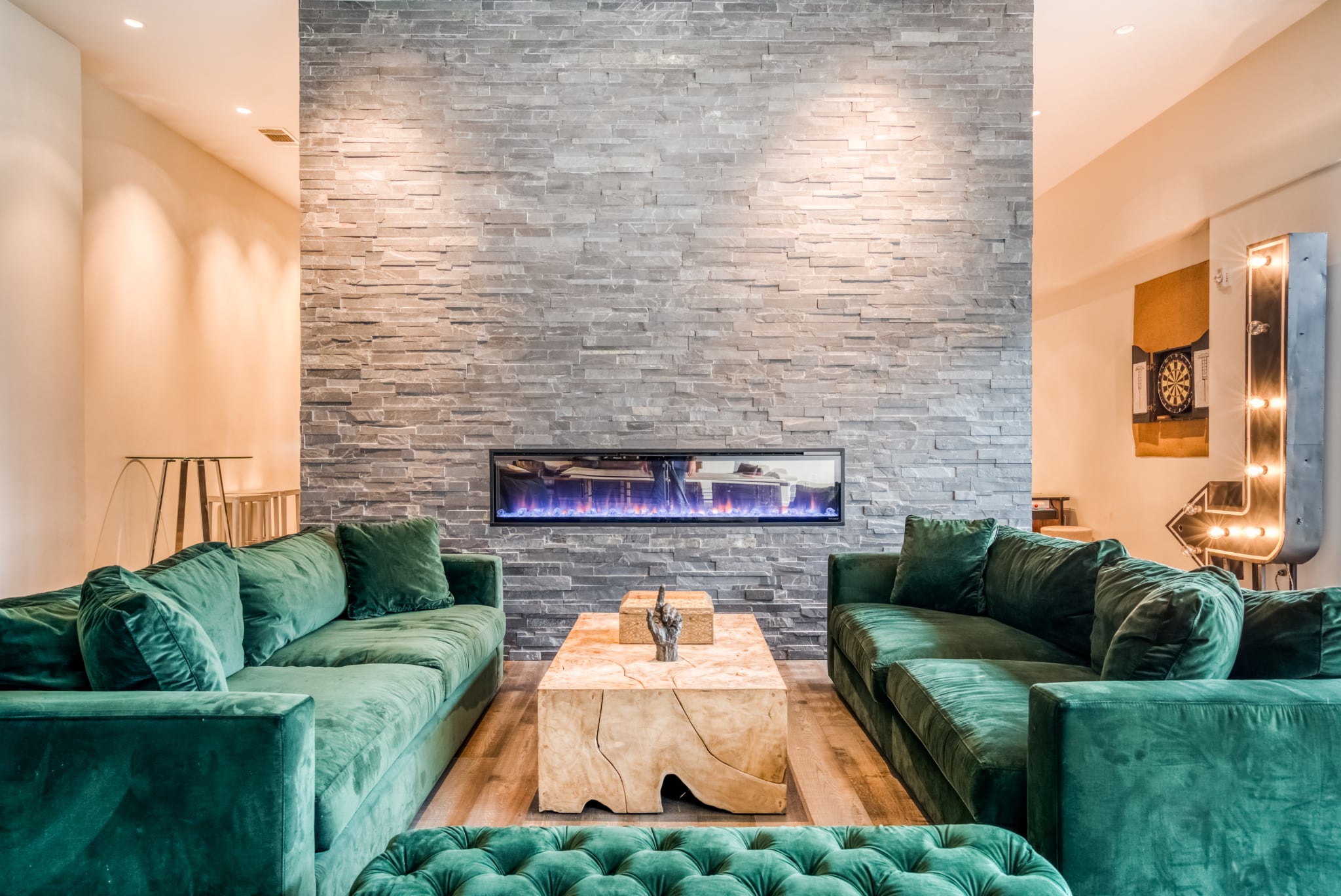 The residents' lounge at Mid Main Lofts with a fireplace and gorgeous emerald green sofas