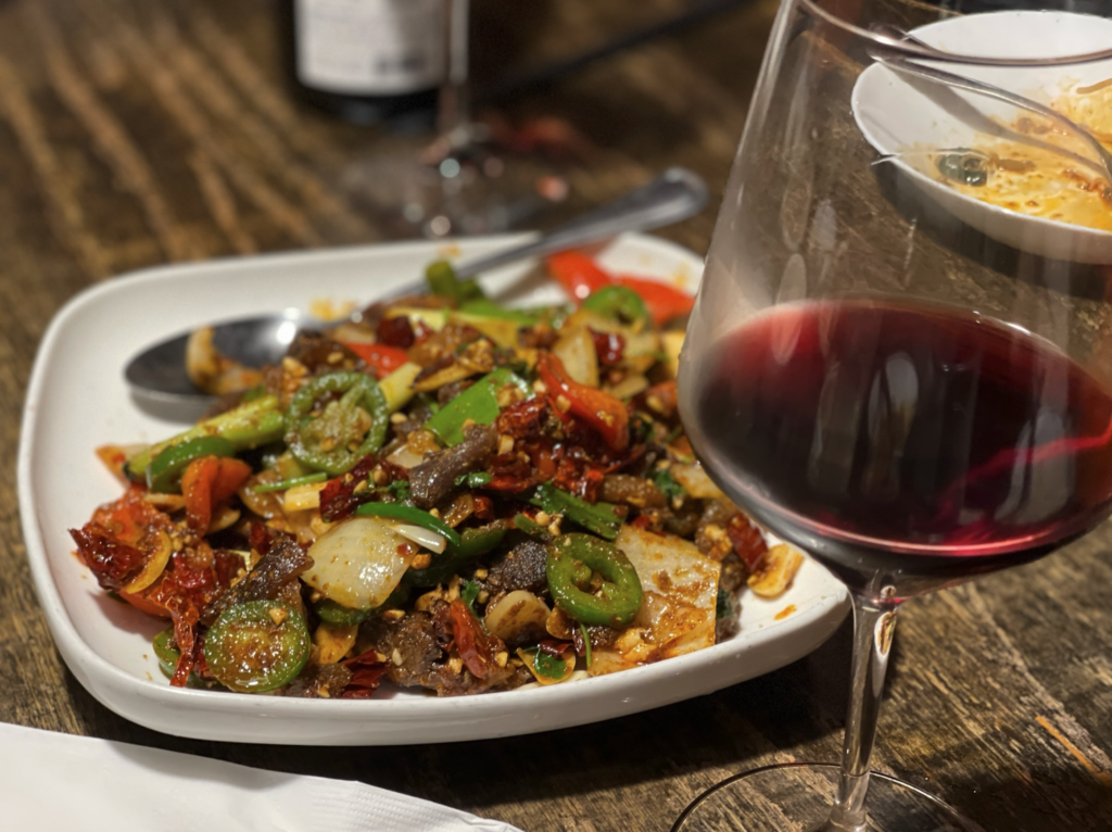 Stir fried beef and a glass of wine at Mala Sichuan in Montrose