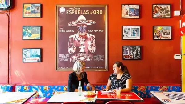Two women having a chat over breakfast tacos