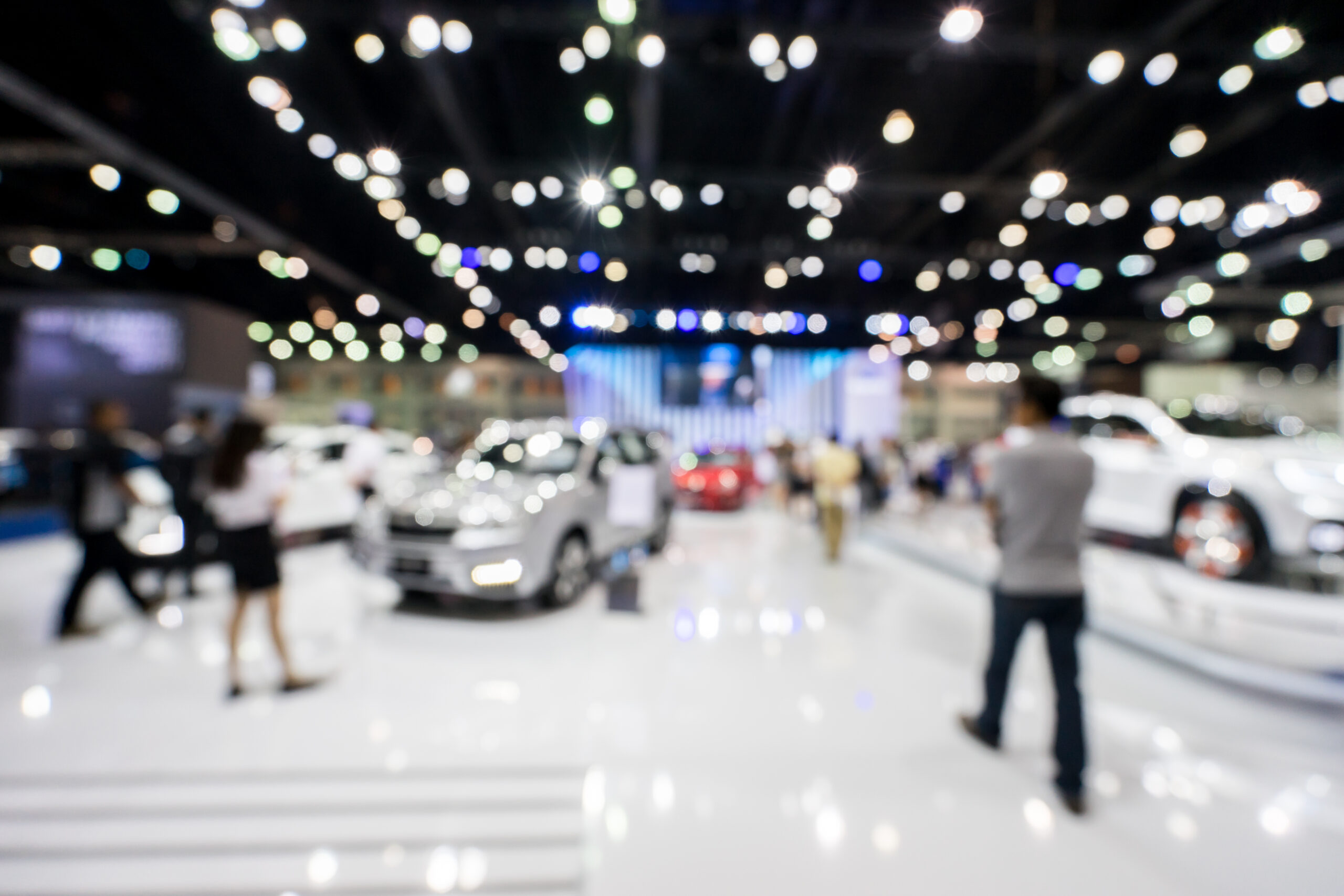 blurred photo of motor show, car show room