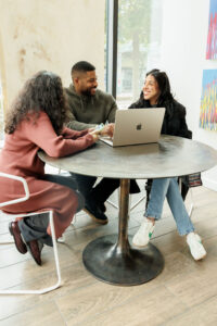 three young professionals at a table with a laptop