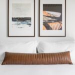 Bed with pillows and two large picture frames above it